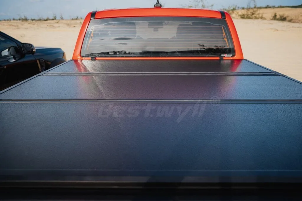 Pickup truck with tri-fold cover driving in desert terrain